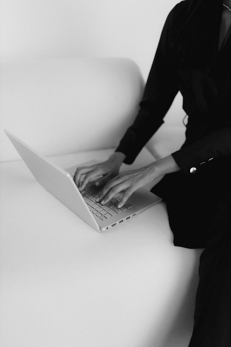 Editorial portrait — laptop work in tailored black