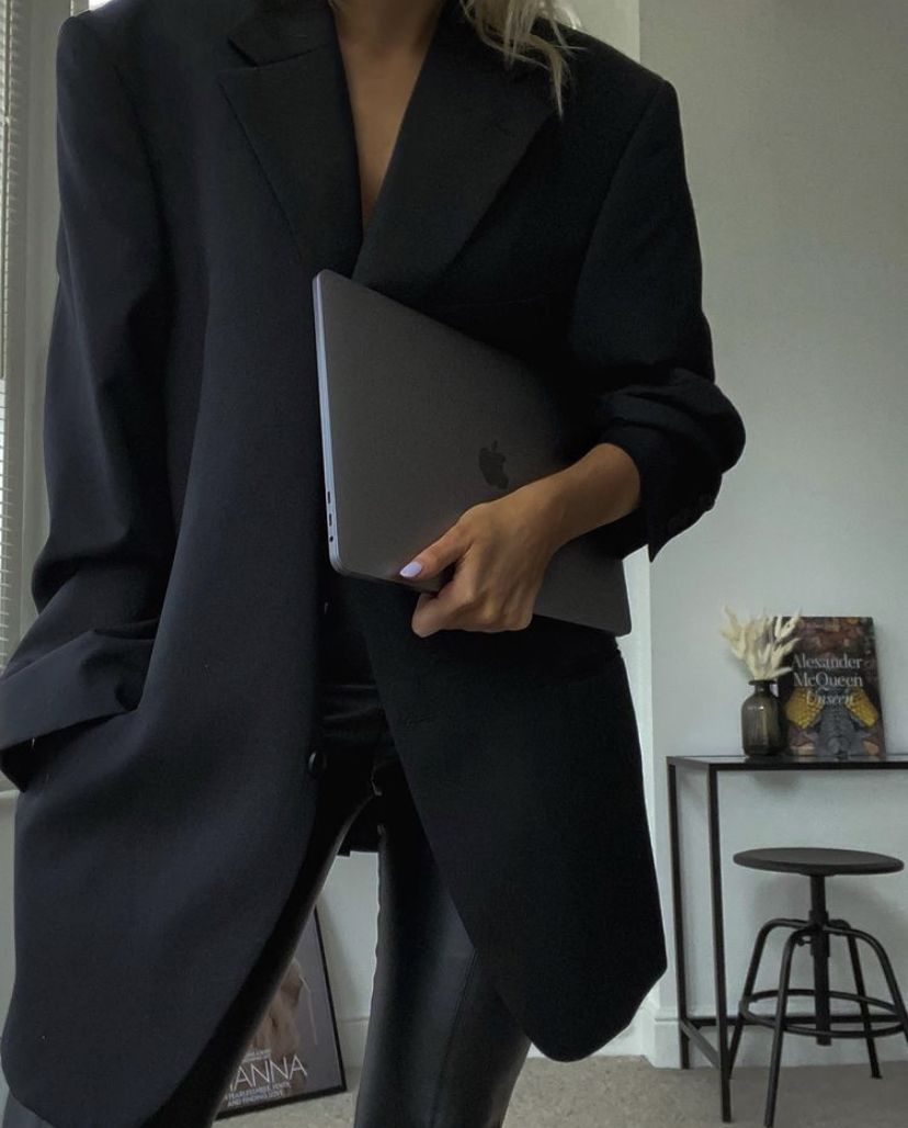 Editorial portrait — oversized black blazer with laptop in hand